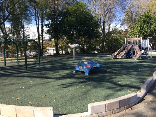 A small kids' playground with soft padded ground.