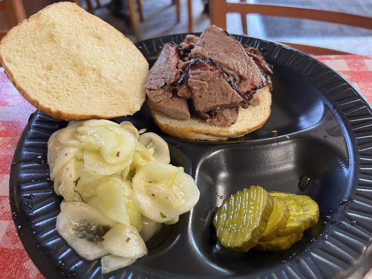 Brisket sandwich with one side- cucumber salad and complimentary pickles.