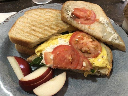 Vegetarian sunrise: Egg, fresh basil, garden tomato, and goat cheese, on perfectly toasted bakery fresh bread.