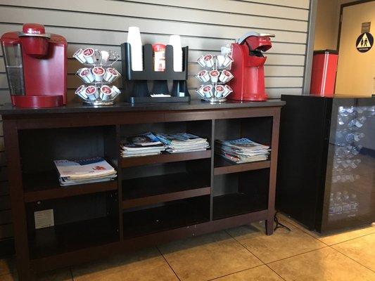 New Keurig coffee machines and Frigidaire full of small water bottles for customers.