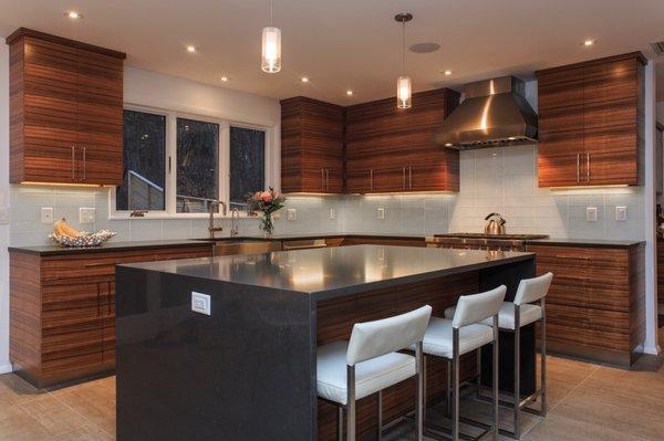 Custom book matched Paldao wood with glass tile backsplash.