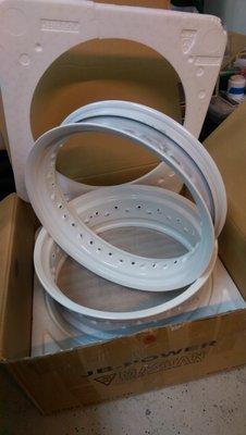 Aluminum supermoto rims that went from one black and one raw, to white powder coat.  Great work!