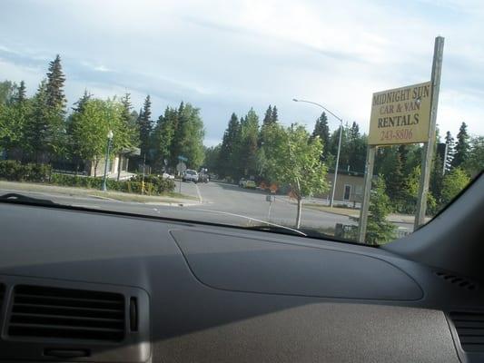 View of our cracked windshield (it came that way) and Midnight Sun Car Rental's sign.