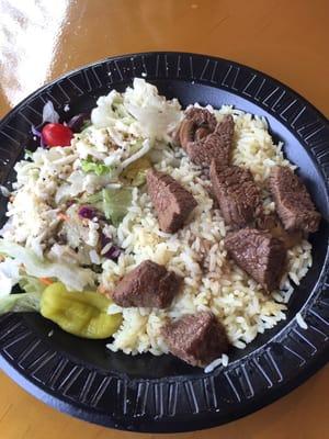 Beef tips over rice and Greek side salad