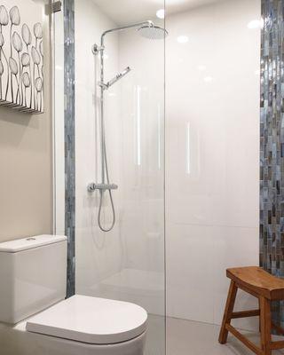 Walk in shower with penny tile base and design shower wall