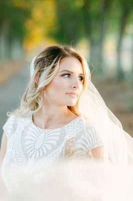 Bride veil shot on private treelined road at farm/barn wedding venue in fall.