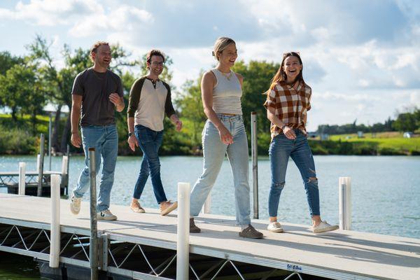 Friends walking on a dock to 1 of many lakeside restaurants.