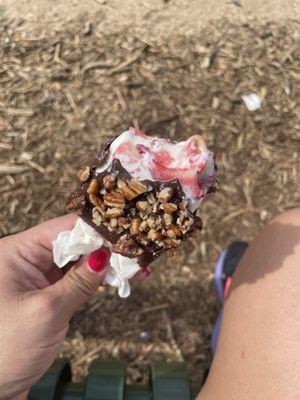 Cream and strawberries covered with chocolate and pecans.