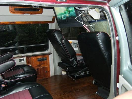 Customized conversion van with installed wood floors, entertainment system and chrome wheels.