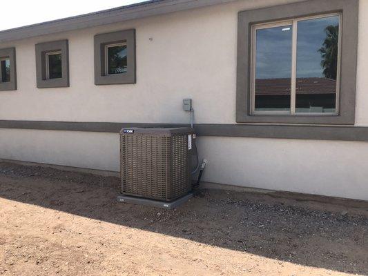 New home construction. York 14 Seer 3ton straight cool Ac condenser with mounting pad, disconnect box & electrical whip