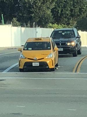 This cab driver opened his window and threw his coffee cup out! You can see it in the street below him. Cant stand people who litter.