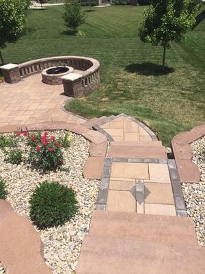 Steps leading down to paver patio with fire pit