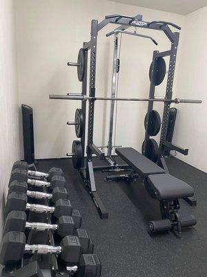 Klutch Strength squat rack, pulley system, bench and bumpers installed