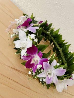 haku lei (flower crown) with orchids, greenery, and baby's breath