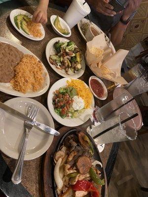 Patron Sizzling Fajitas with a side of sautéed veggies and avocado slices.