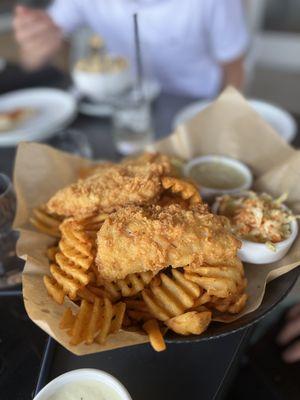 Three amazing pieces of fish on a huge mound of wonderfully made waffle fries.