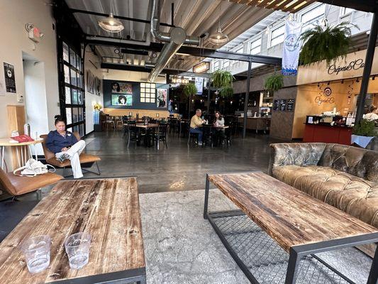 Indoor seating area, brewery in the back and Crepes&Co to the right