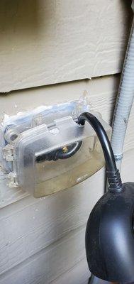 Outdoor outlet installed upside down, which would allow rain to pool if not corrected.