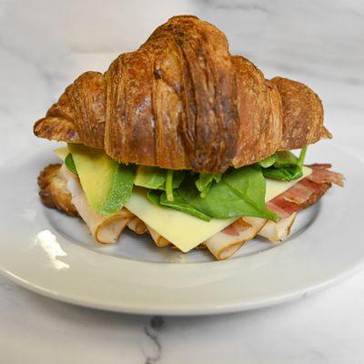 Turkey bacon avocado sandwich: Turkey, bacon, white cheddar, avocado, spinach, and mayo, served on a Farm to Market croissant