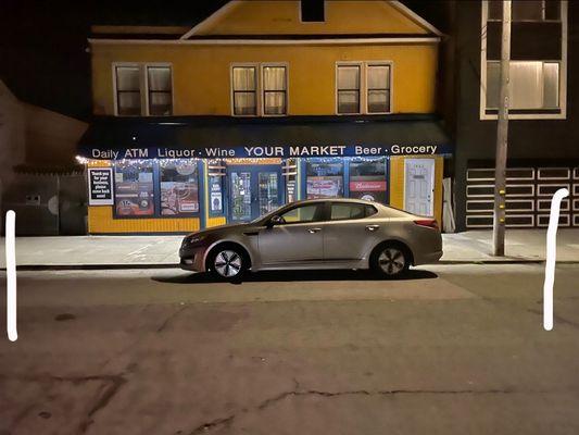 The store owner thinks he owns this 2 car parking spot. He takes up the whole thing to save himself a spot for when he comes in the morning.