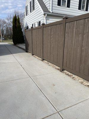 Beautiful composite fence along driveway