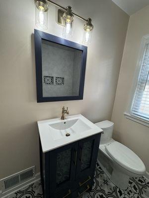 Remodeled Navy Vanity & champagne bronze fixtures