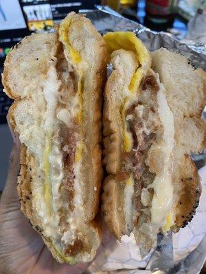 The SHU- bacon, egg, fried egg, cheese, and a has brown on a Portuguese roll with a bite taken out