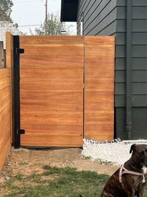 1inch and 5inch alternating clear boards on this modern 6 foot privacy horizontal gate with black hardware and black metal post.