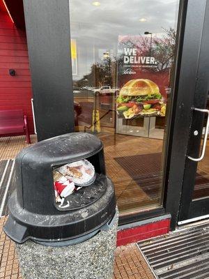 Over flowing trash at the entrance to Red Robin Columbia Center Blvd.