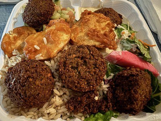 Falafel plate with rice, hummus and cucumber-tomato salad.