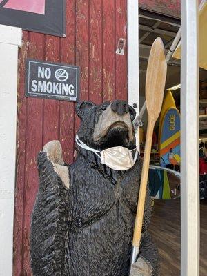 Carved wooden bear out front, fully vaccinated because their mask is off