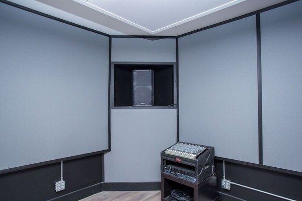 Acoustically treated wall with a QSC K12 speaker compartment built into 1 of 4 bass traps. (2 speakers per room)