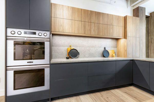 Large U-shaped kitchen features two-tone cabinetry, automated upper cabinet doors, integrated storage features and an appliance garage.