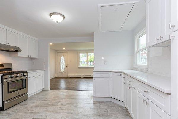 Modern white kitchen renovation with matte ceramic tile floors