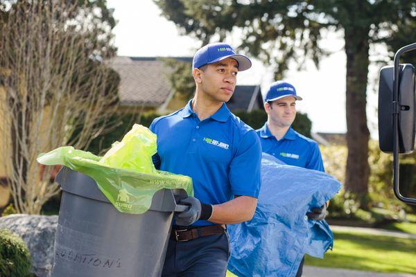 1-800-GOT-JUNK? Truck Team Members carrying trash cans