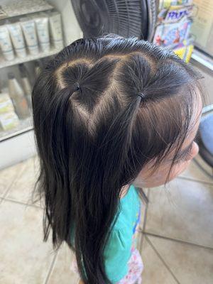 Adorable heart-shaped hairstyle by Rocío, the owner, after the girls (ages 5 and 7) got their hair cut.