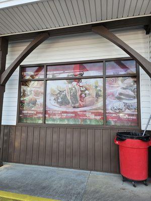 The large windows behind which is a counter with seats.