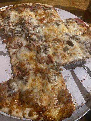 Large pizza with mushrooms and half Canadian bacon and half sausage