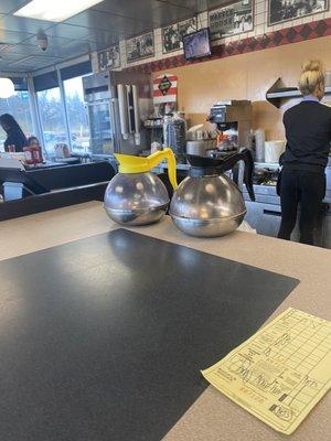 Chocolate milk sitting next to the refrigerator for an hour or more.  Why are there empty coffee pots on the bar?