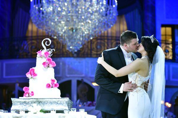 Bride & Groom Kiss after cutting their wedding cake at Venetian, Wedding venue in Garfield, New Jersey