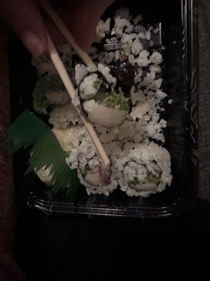 Yellowtail Scallion Maki-one roll with outer rice peeled off, rest with it still on