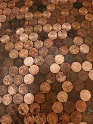 Bathroom floor made out of pennies.