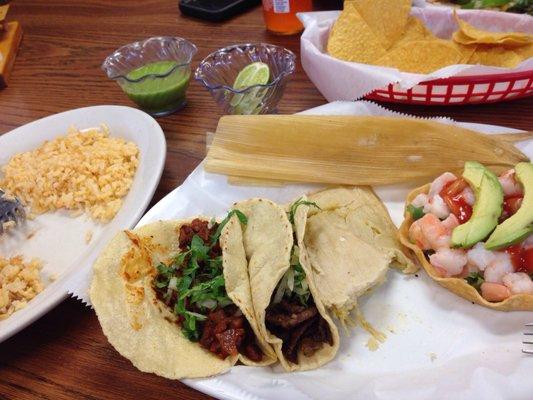 Steak and al pastor tacos, chicken tamale and shrimp tostado