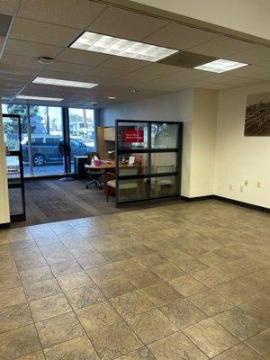 Empty offices while employees shoot the breeze with a full line for a teller