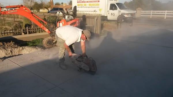 Saw Cutting Through Concrete to Replace Water Main and Sewer Main