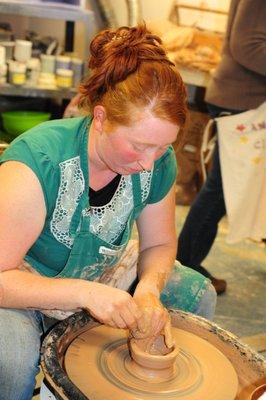 Pottery Student throwing on the wheel.