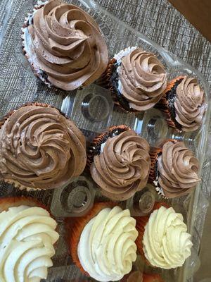 Chocolate cupcakes that were ordered with chocolate frosting, after they scraped the white frosting mistake off.