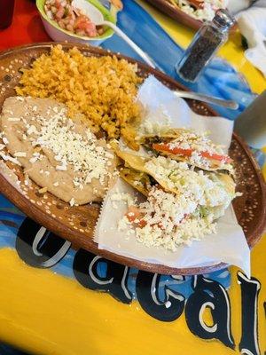 2 ground beef tacos with a side of rice and beans.