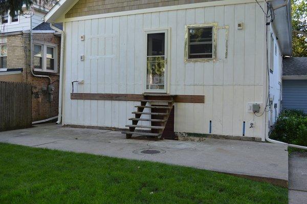 Old and busted pad and stairs going to basement. Catch basin still installed.