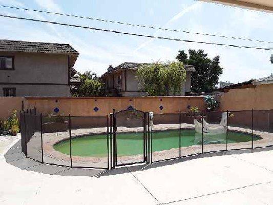 Removable mesh pool fence installed in Arleta with an arch top gate. 877-521-5569